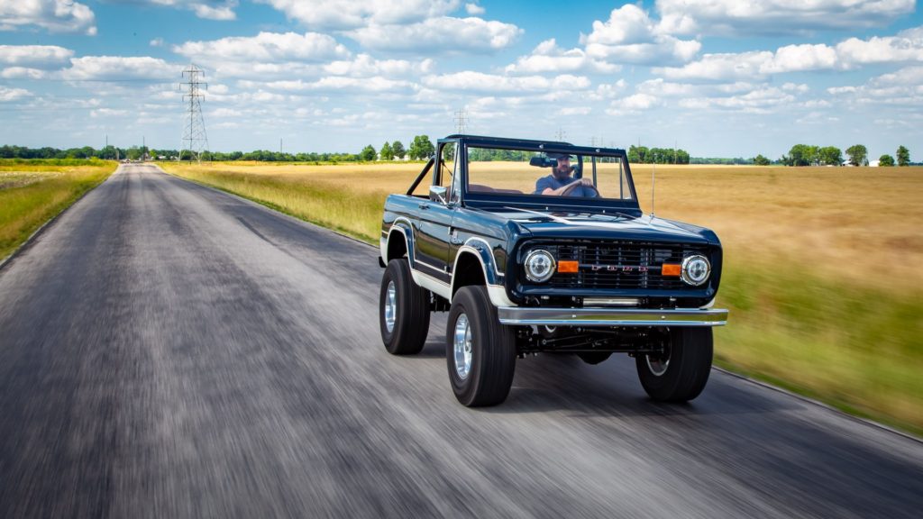 Man Driving 1967 Ford Bronco in Field