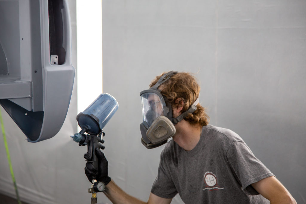 Man painting in the factory. Auto tech internship program expanded.