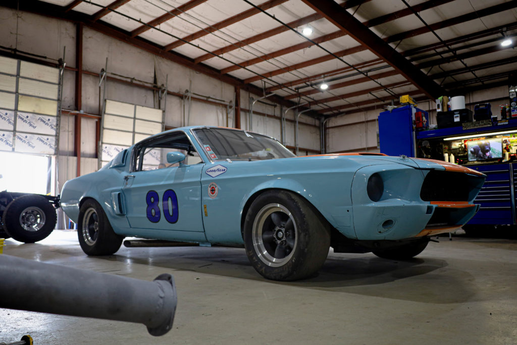 The number 80 on the door of a light blue Shelby.